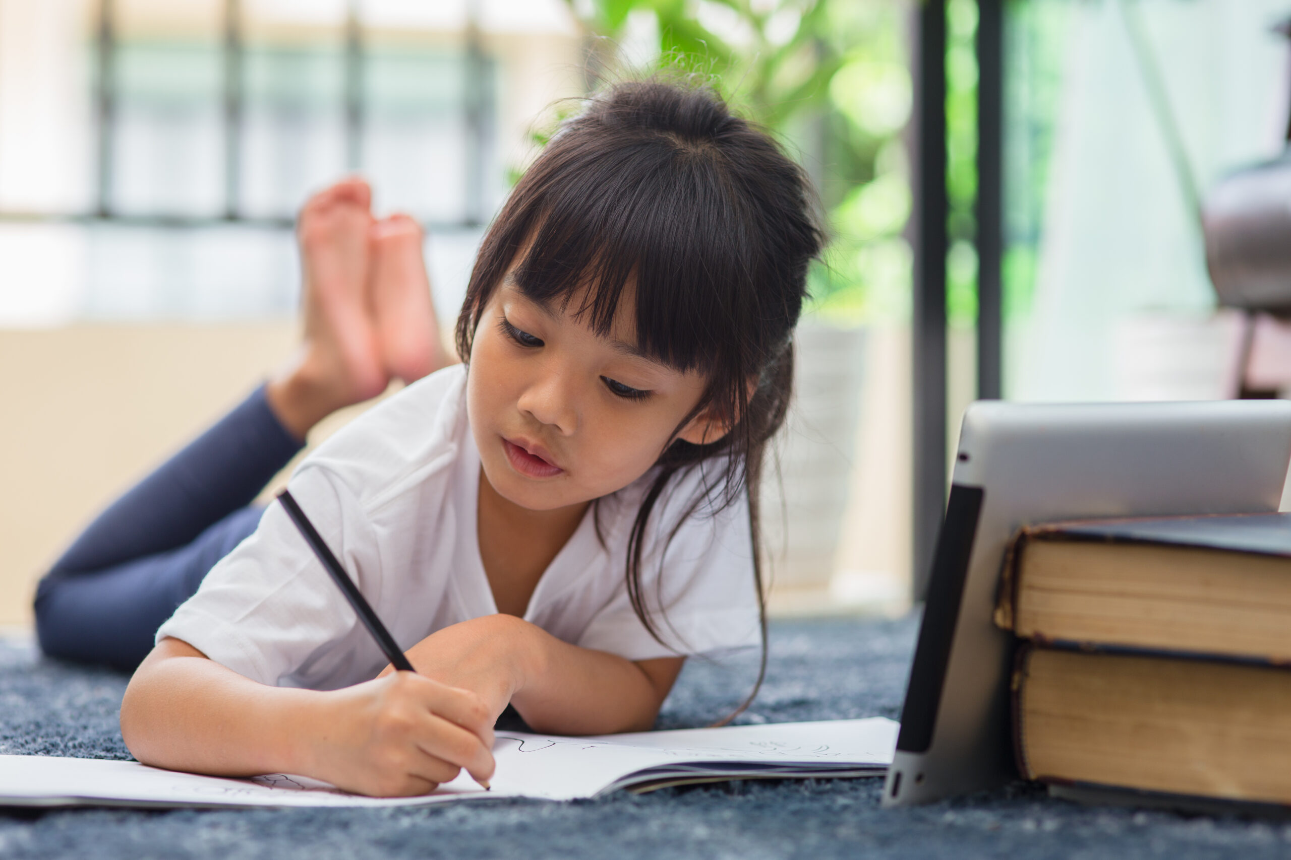 Portrait of preschool kid using tablet for his homework.